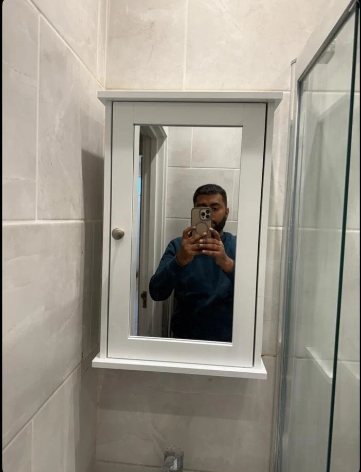 Bathroom mirror cabinet mounted on tiled wall